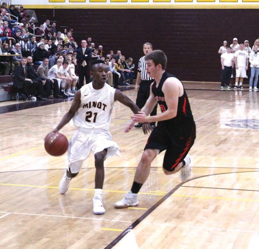 Mark Jones/MDN Senior guard Trevor Banks (21) shields his defender away from the ball in a West Region conference game against Dickinson on Dec. 10 at Minot High School. The Magi won 64-58.